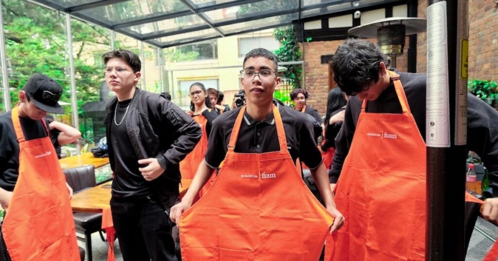 Jóvenes en formación de la Academia Ñam en Bogotá, servicio a la mesa.