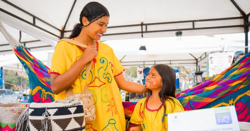 Emprendedora víctima del conflicto mostrando artesanías Wayúu en la feria Sembradores de Paz 2025