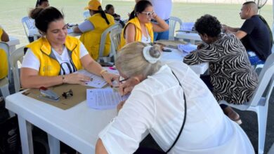 Funcionaria de la Unidad para las Víctimas entregando una carta de indemnización a un beneficiario en Santa Marta, Magdalena.