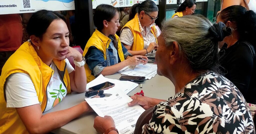 Mujeres y hombres víctimas del conflicto armado recibiendo documentos de indemnización económica en jornada de la Unidad para las Víctimas.