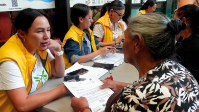 Mujeres y hombres víctimas del conflicto armado recibiendo documentos de indemnización económica en jornada de la Unidad para las Víctimas.
