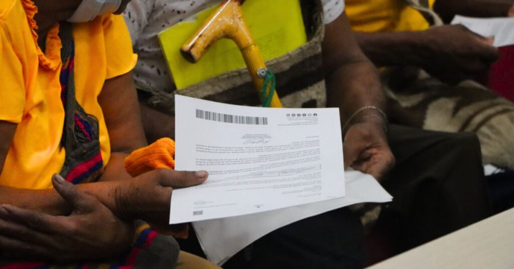 Funcionarios entregando la carta de pago de indemnización a una víctima del conflicto en el Cesar o La Guajira