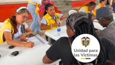 Funcionarios de la Unidad para las Víctimas entregando sobres con cartas de indemnización a beneficiarios