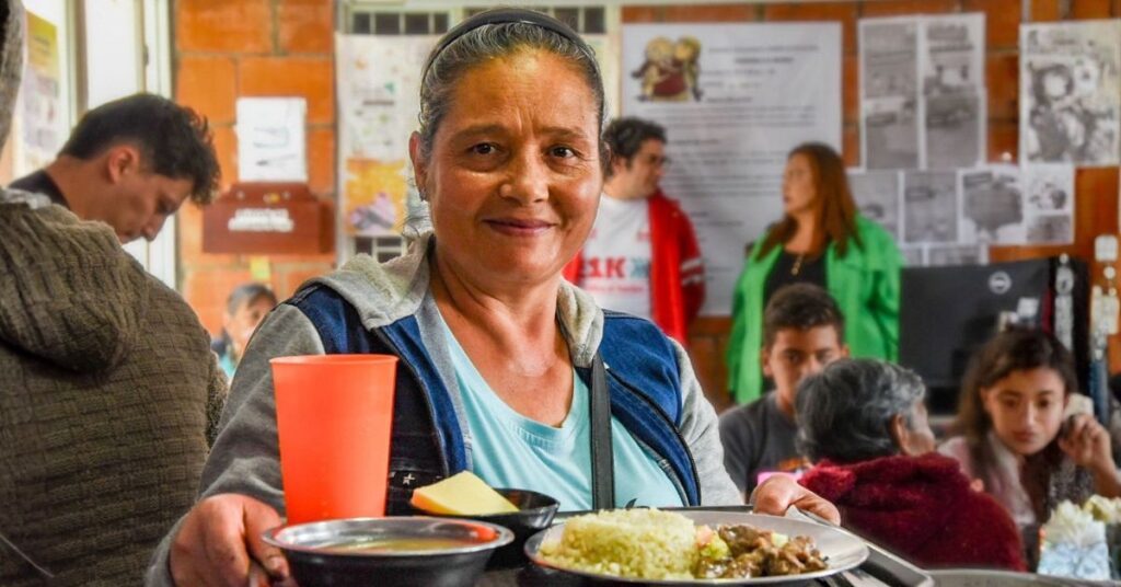 Familias en Bogotá recibiendo apoyo alimentario en un comedor comunitario del Distrito